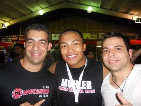 Felipe Soares in a white shirt standing with coach Keiser Girao in a Team Minotauro Dallas shirt and a teammate at a grappling event.