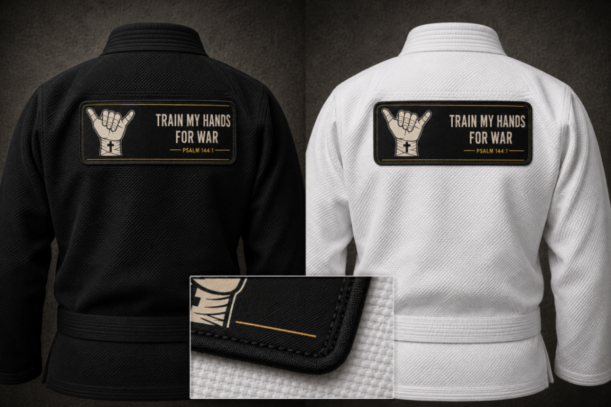 Product mockup: large woven TMHFW gi back patch, roughly 8 inches wide — ivory shaka crest with gold outline on black twill with a merrowed edge, sized for the upper back panel of a gi jacket